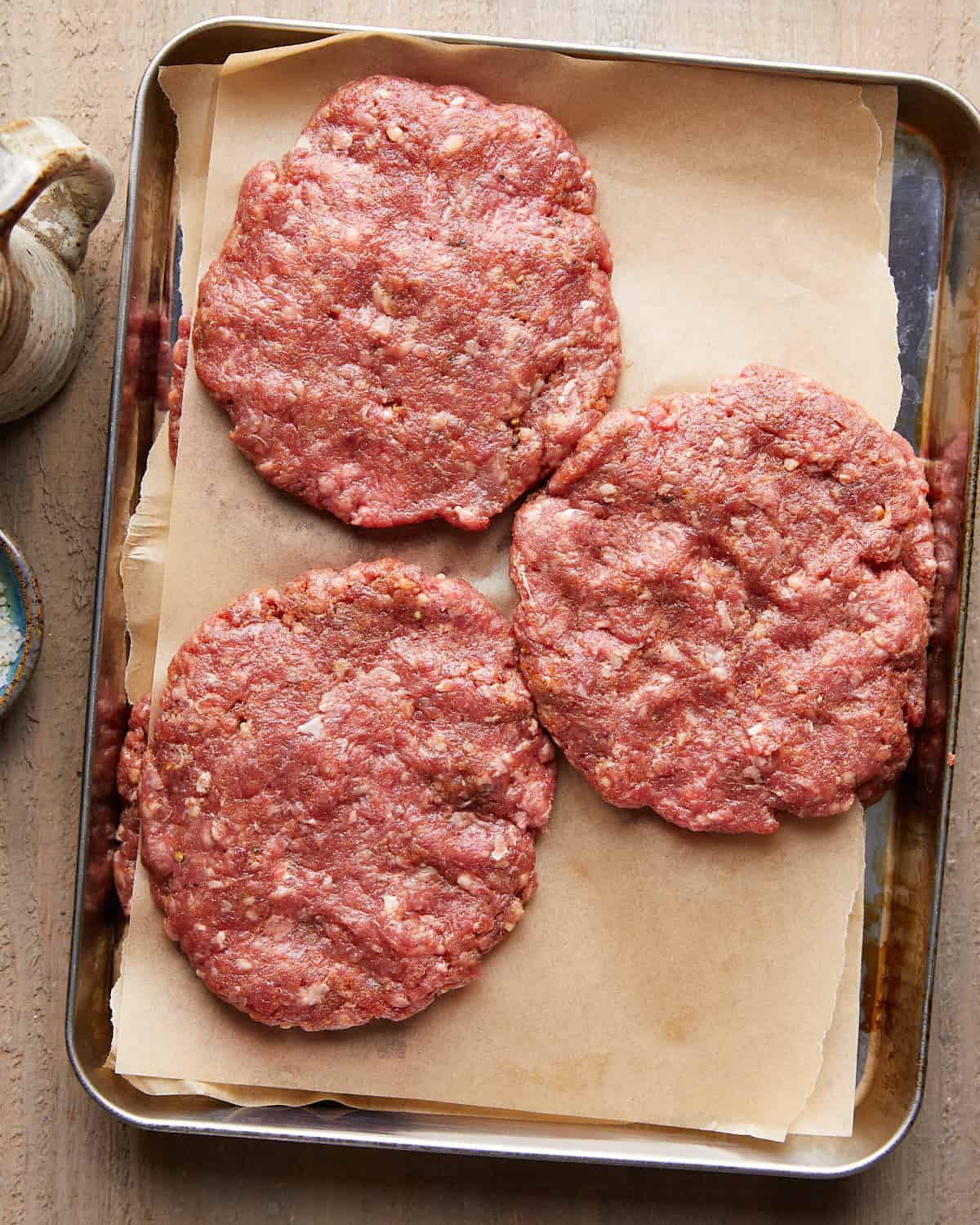 Overhead image of raw hamburger patties.