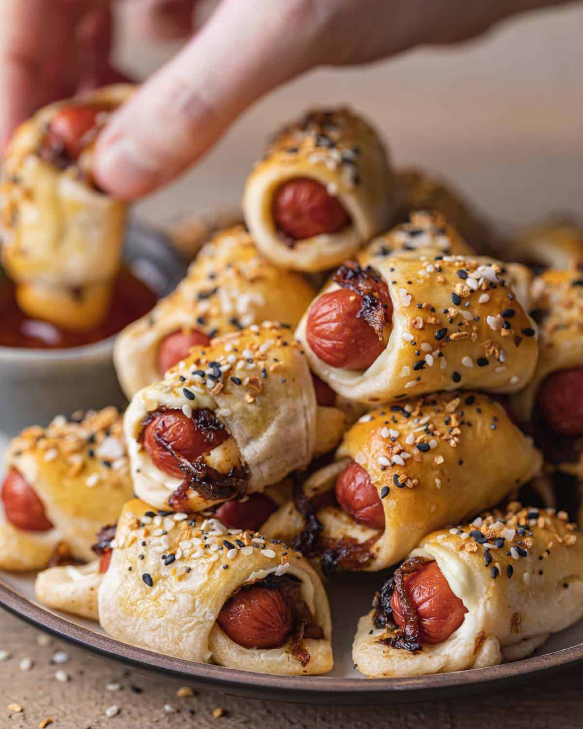 Side view of pigs in a blanket stacked on plate