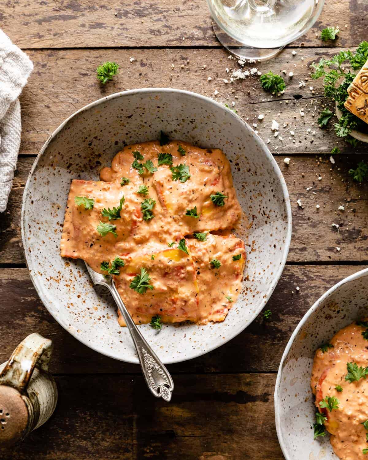 overhead shot of pink sauce tossed with lobster ravioli in a bowl