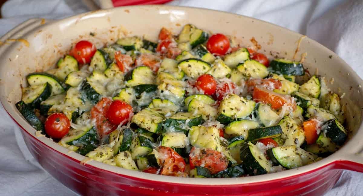 Baked tomato and zucchini in a red dutch oven.