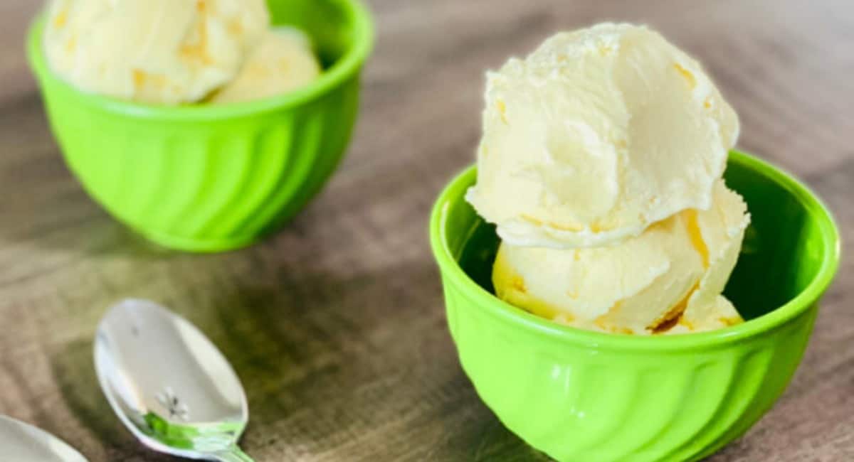 Homemade mango ice cream served in a green bowl.