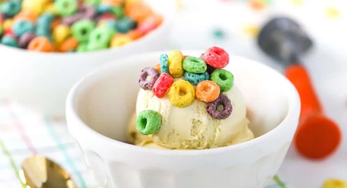 Cereal milk ice cream topped with cereal in a white bowl.