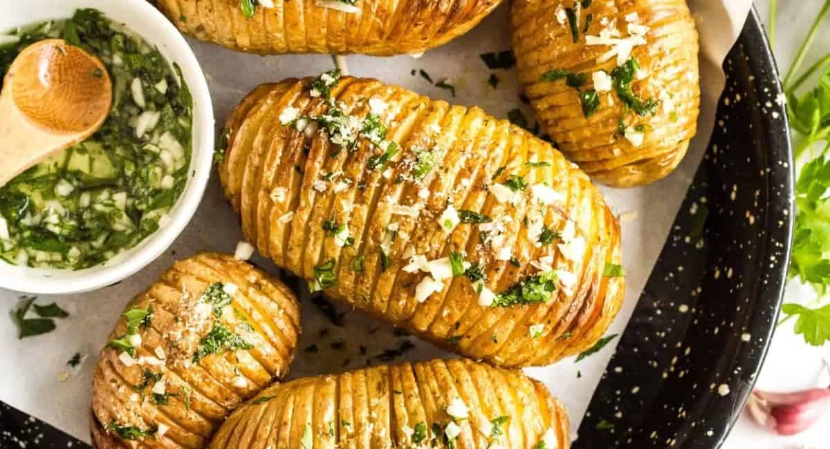 Hasselback potatoes on a black plate.