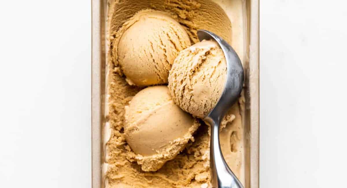 Spiced chai ice cream being scooped by an ice cream scooper.