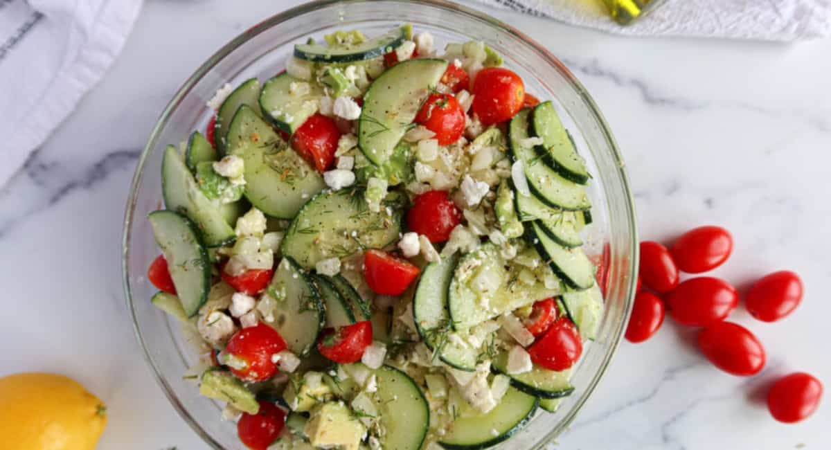 Cucumber and onion salad in a clear bowl.