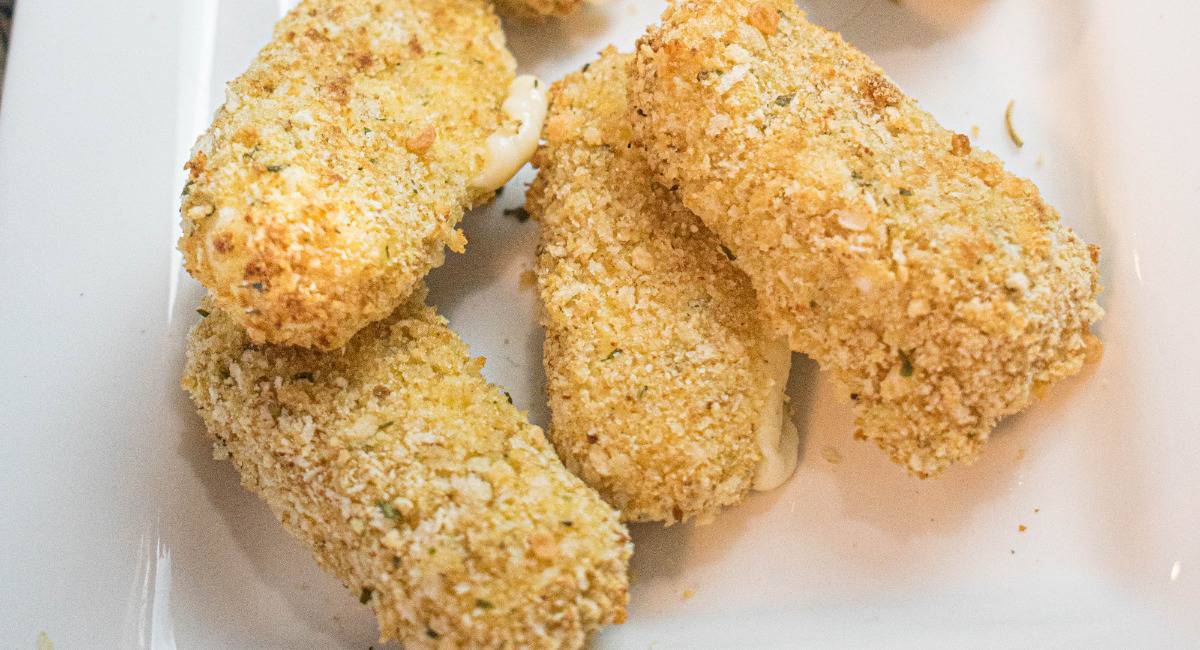 Mozzarella sticks on a white plate.