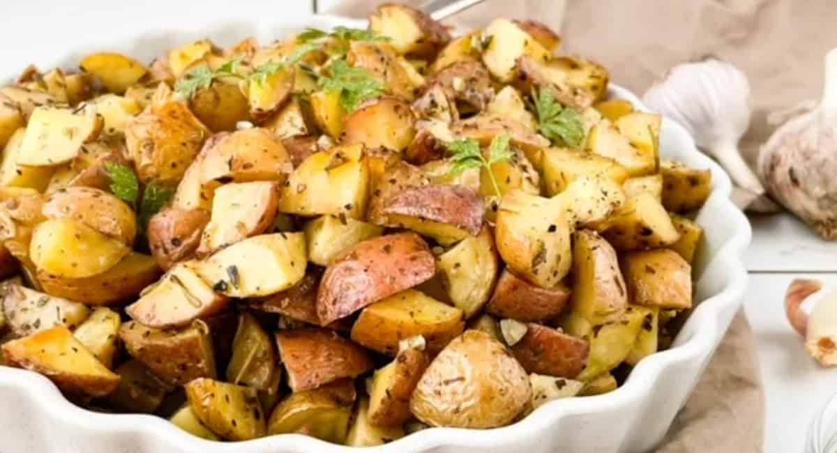 Roasted potatoes in a white serving dish.