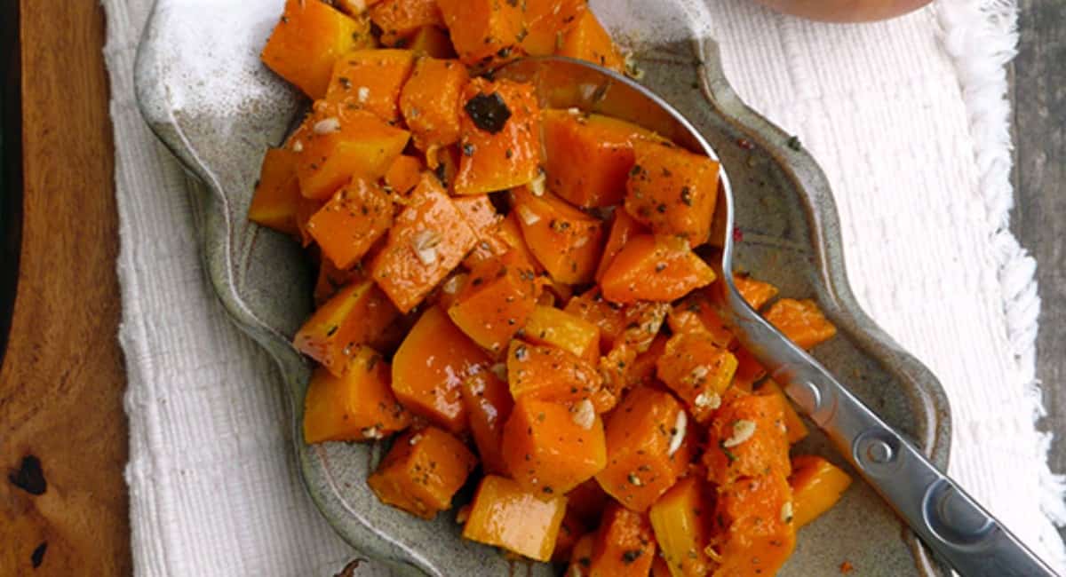 Roasted butternut squash in a silver serving bowl.