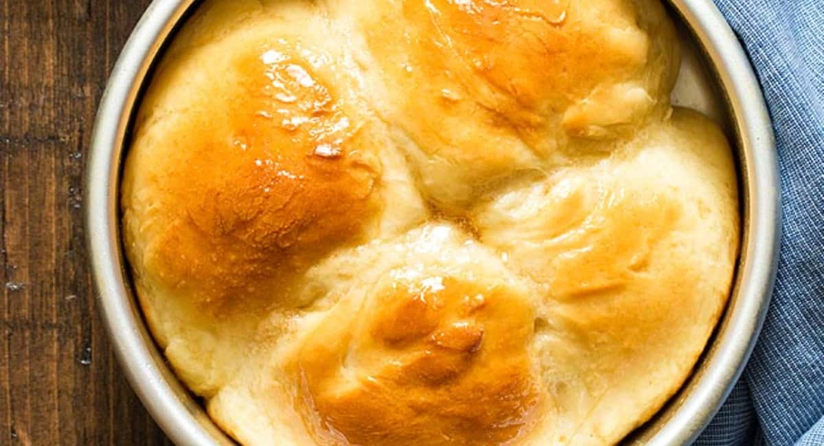 Round pan with four dinner rolls.