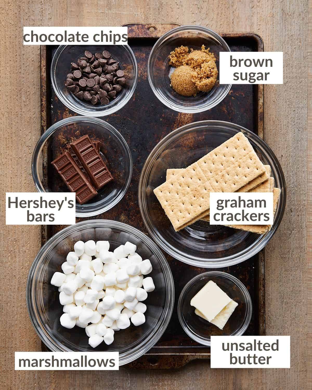 Overhead shot of ingredients needed for mini smores pie in glass bowls. 