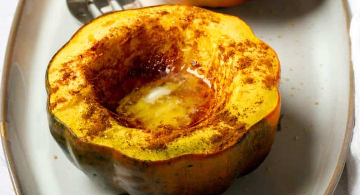Acorn squash fresh out of the air fryer and served on a white plate.