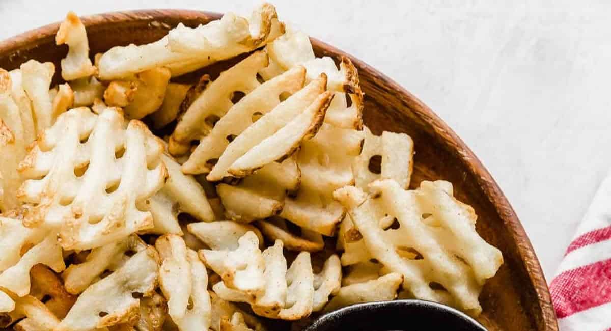 Waffle fries in a brown bowl.