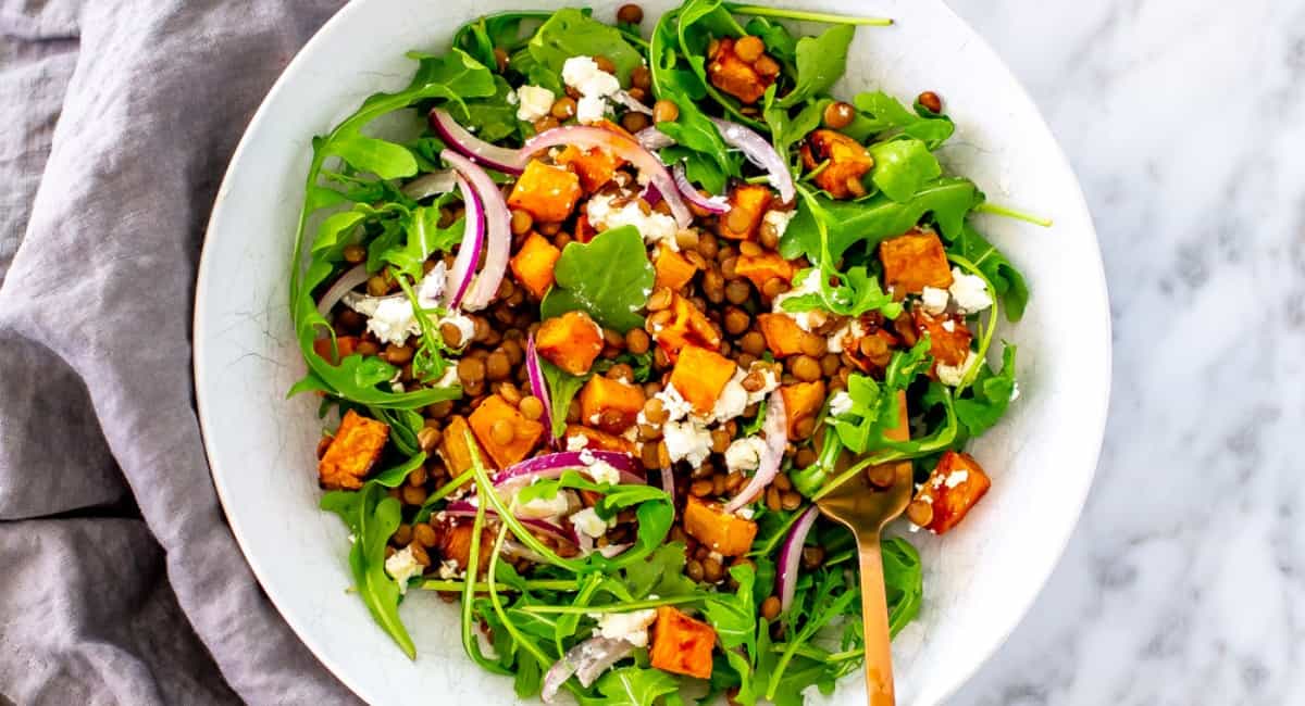 Arugula salad in a white bowl.