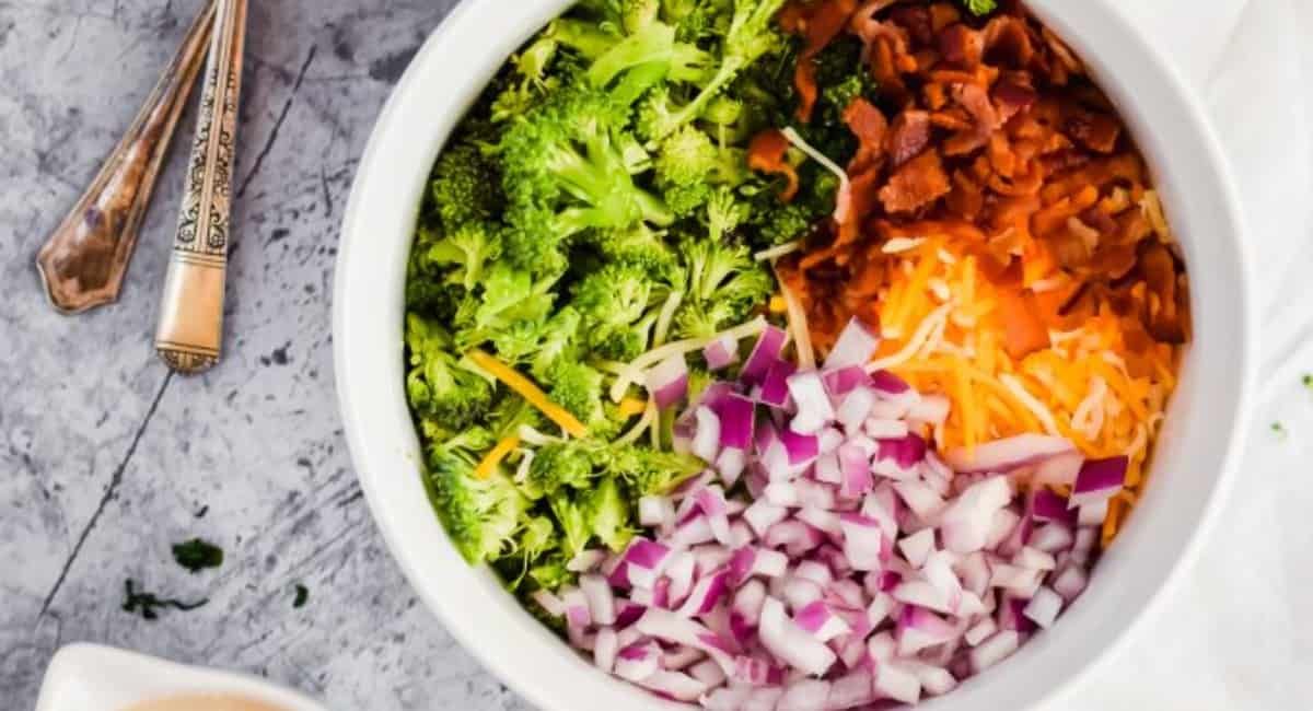 Broccoli salad served in a white bowl as a side for meatball subs.