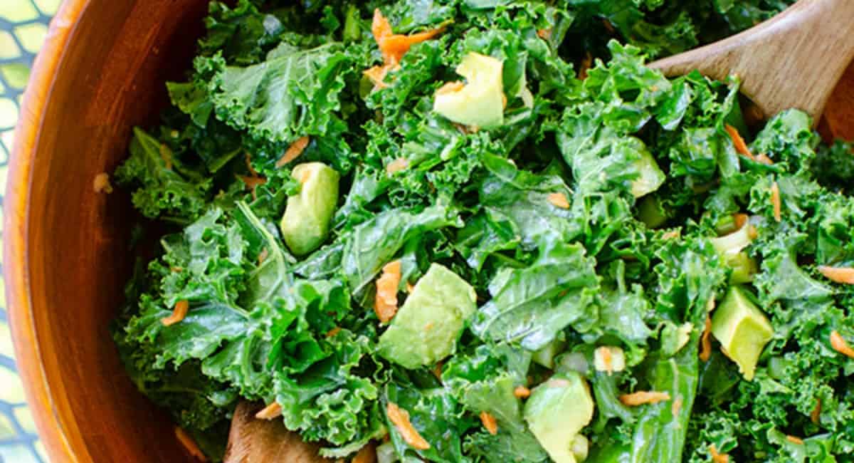 Kale avocado salad in a brown bowl.