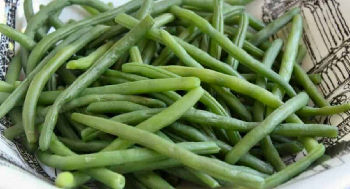 Green bean salad in a black and white bowl.