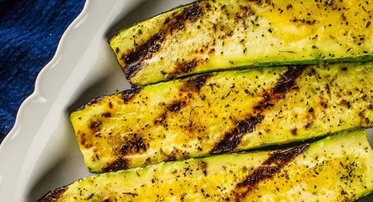 Grilled zucchini on a white plate.