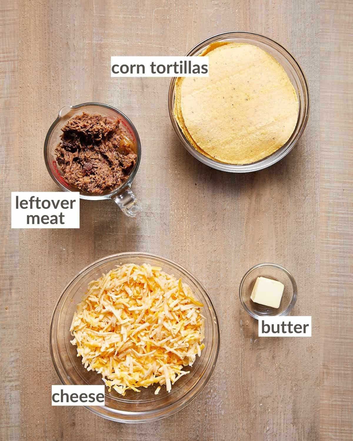 Shows all of the ingredients needed to make corn tortilla quesadillas in glass bowls. 