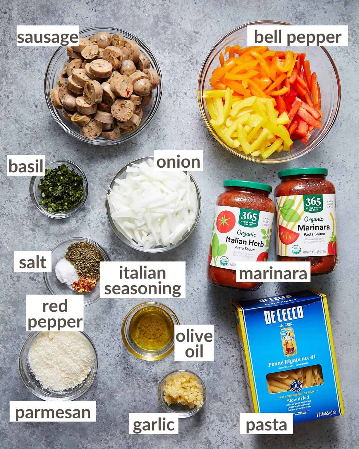 Ingredients needed in glass bowls to make pasta with sausage and peppers.