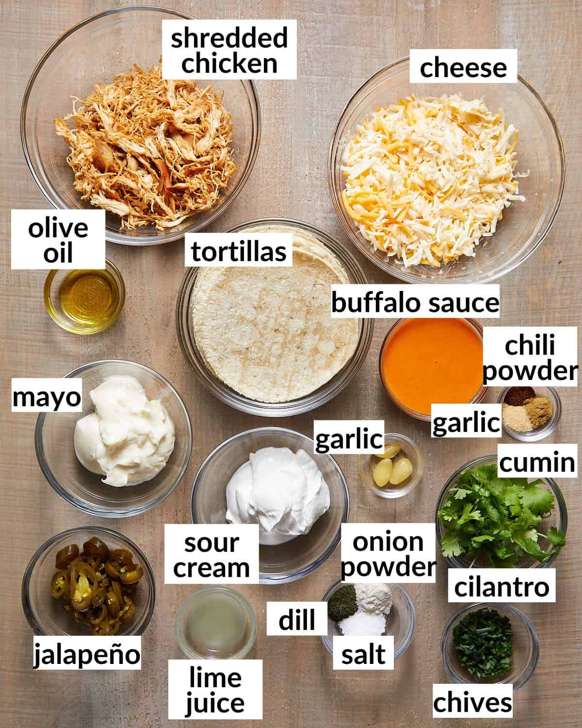 Ingredients needed to make buffalo chicken tacos in glass bowls. 