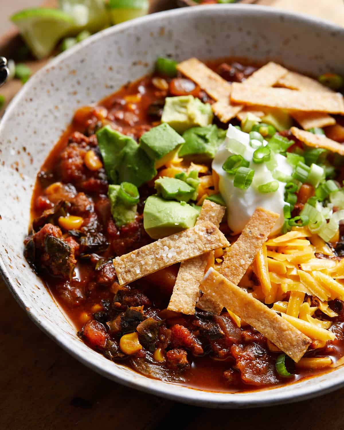 Close up image of no bean turkey chili garnished with tortilla chips and shredded cheese.