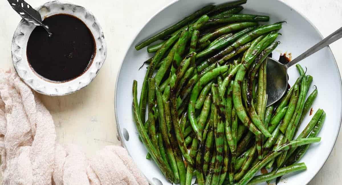 An overhead image of balsamic green beans on white dish.
