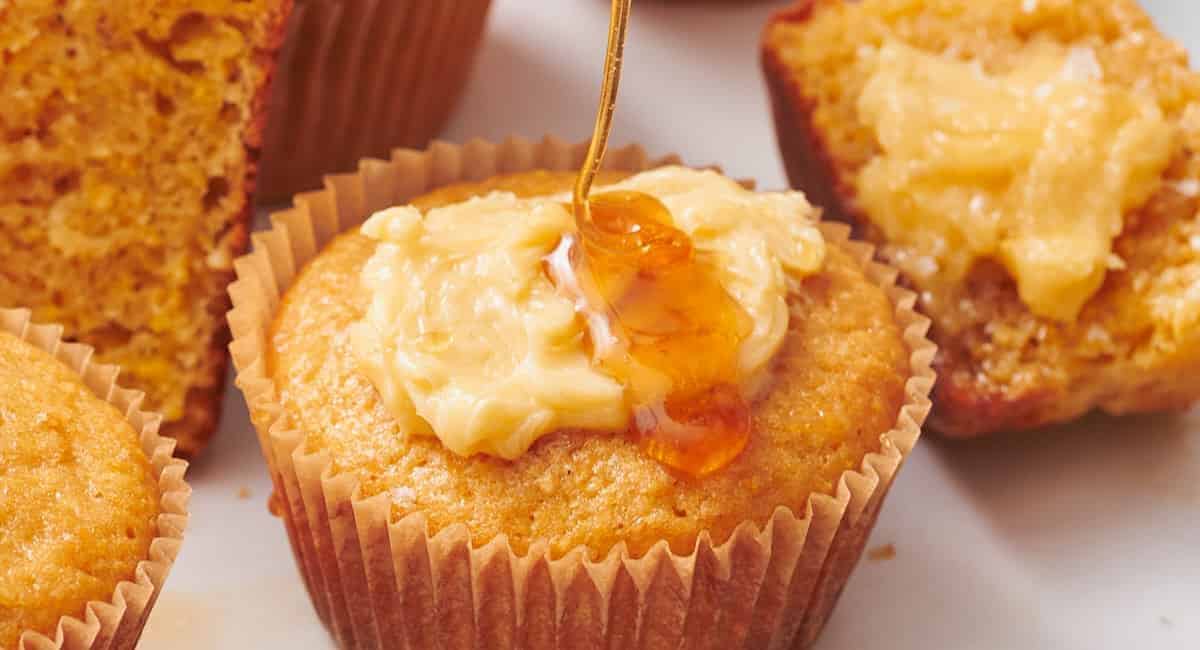 Photo of sweet honey cornbread muffin with honey drizzle. 