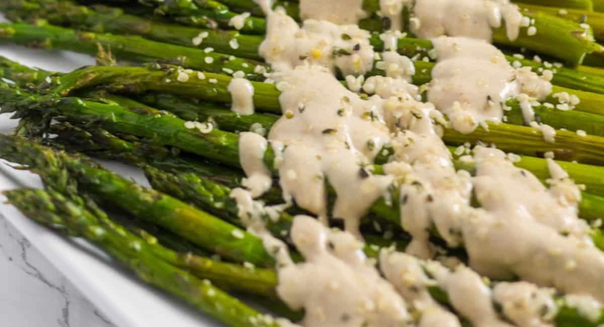 A photo of roasted asparagus with lemon tahini sauce. 