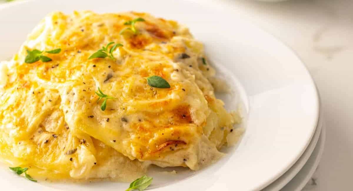 A photo of scalloped potatoes on white dish. 