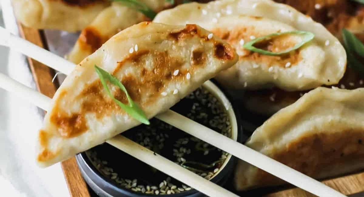 Overhead image of Chinese chicken dumplings with sesame soy sauce.