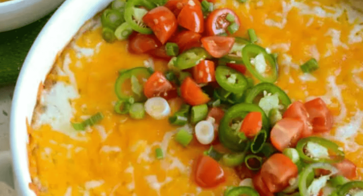 Overhead image of warm bean dip with garnish in white bowl.