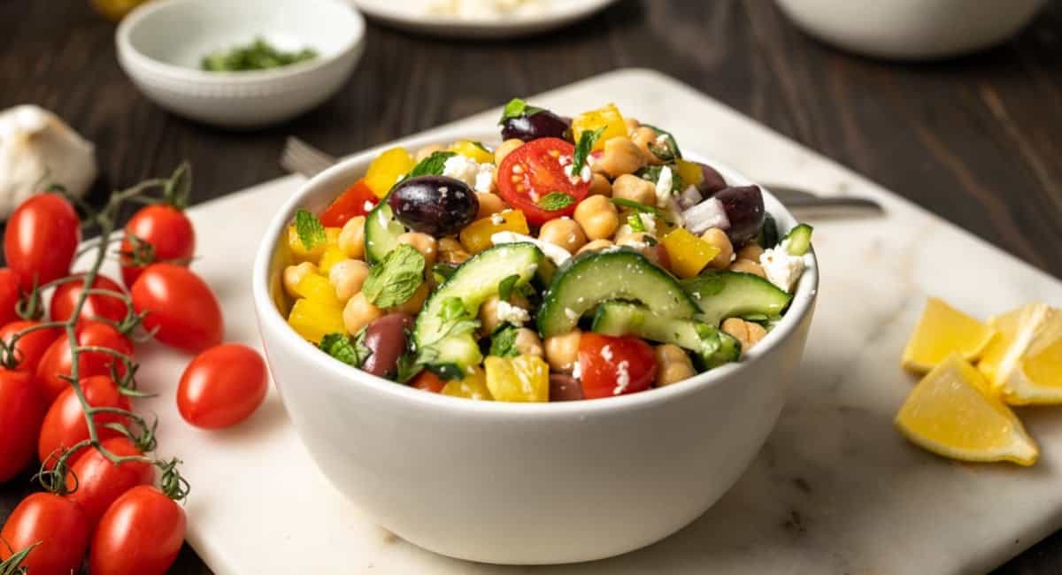 Up close image of greek chickpea salad in white bowl.