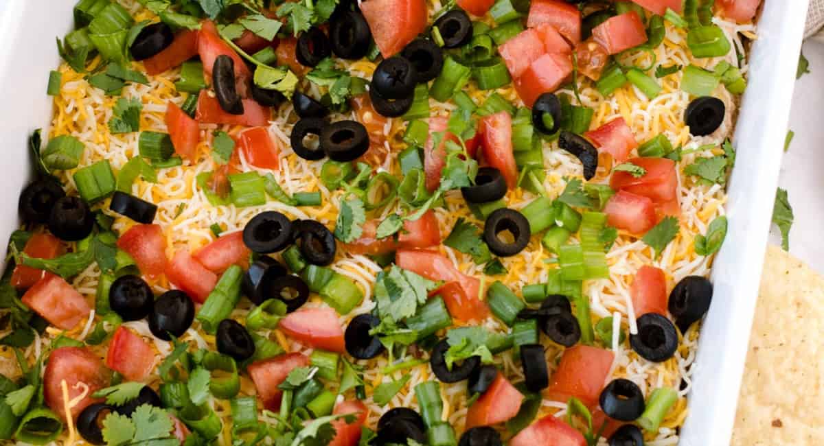 Overhead image of taco layer dip with garnish.