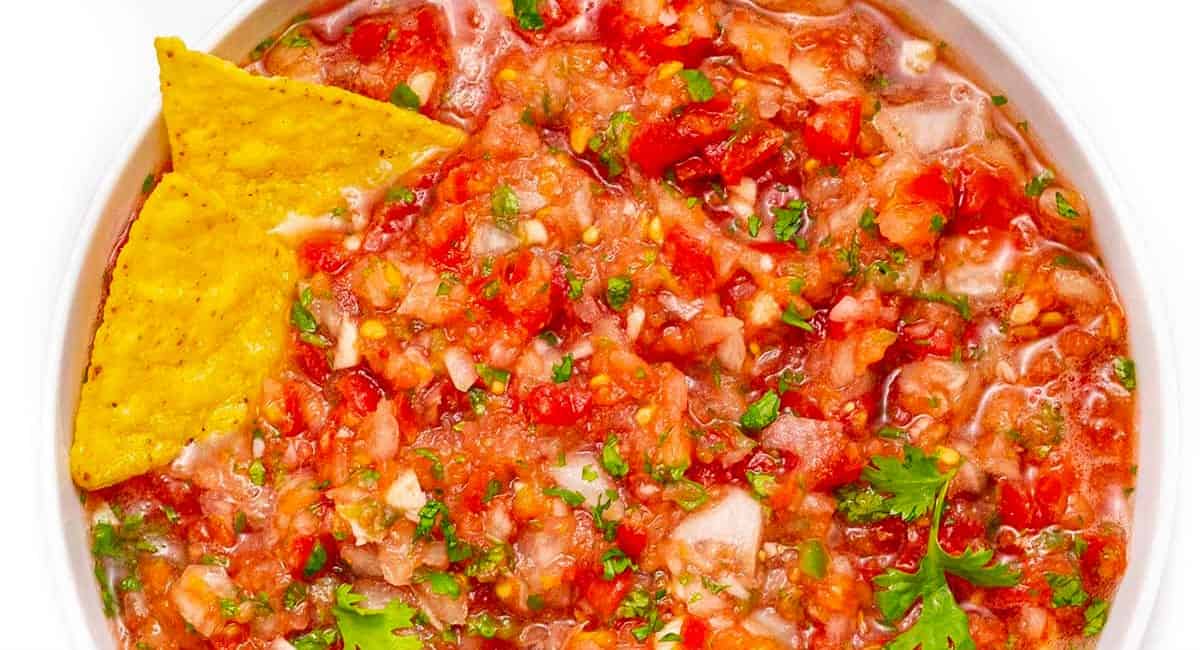 Overhead image of homemade salsa with fresh tomatoes and cilantro.