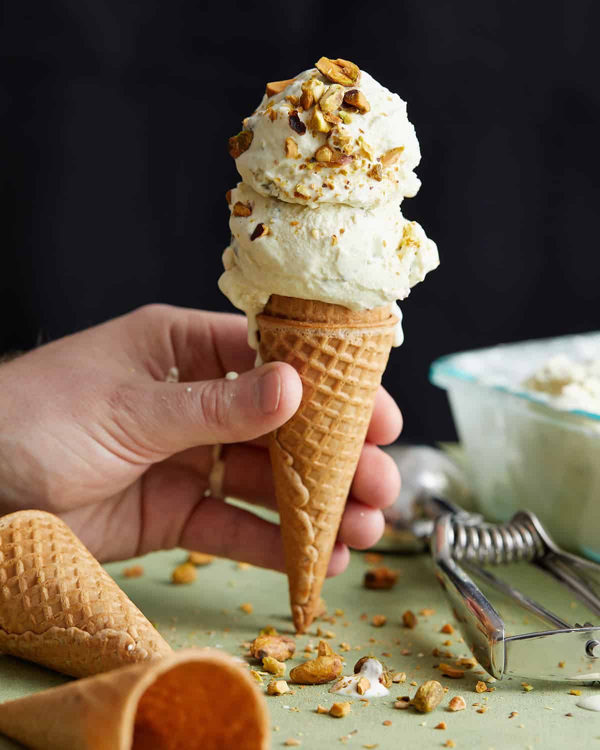 Up close photo of pistachio ice cream on a waffle cone.