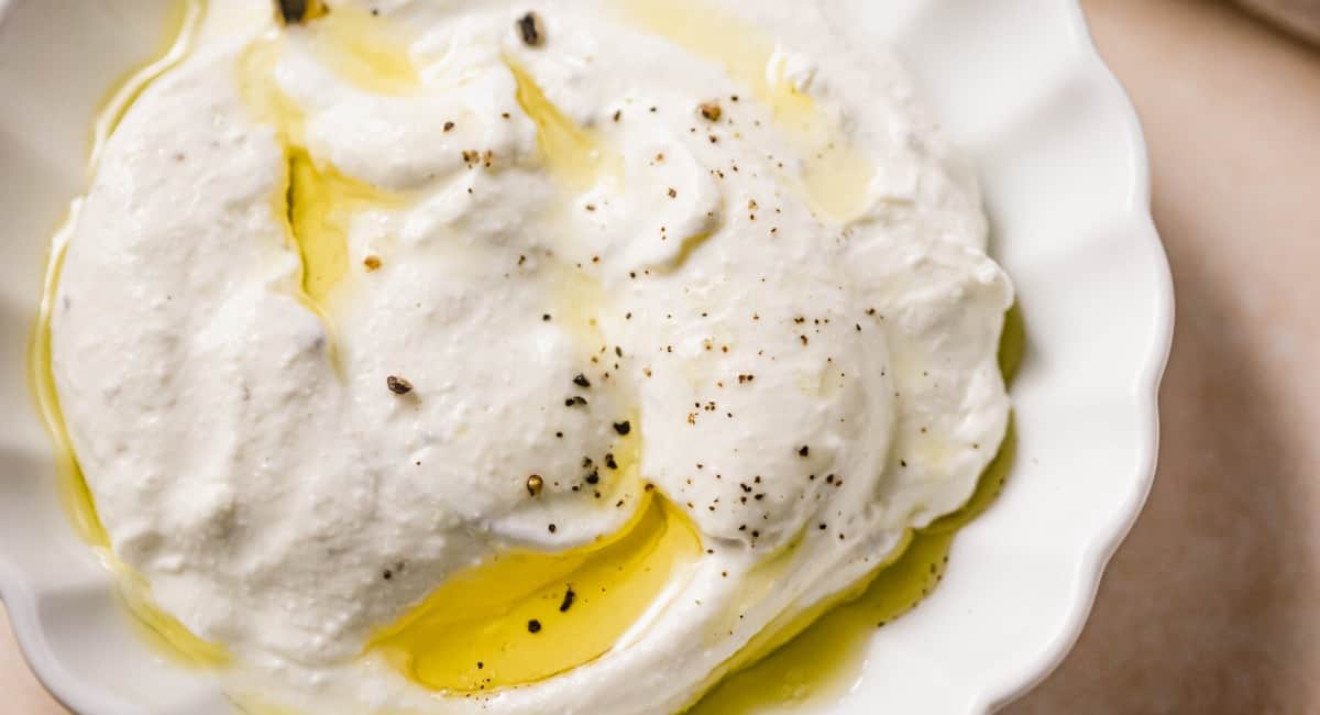 Overhead image of whipped ricotta with honey and garnish.