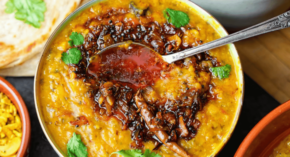 Overhead image of arhar dal tadka with garnish.