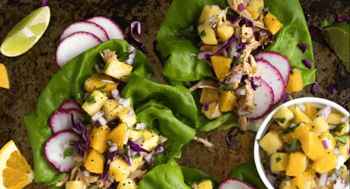 Overhead image of slow cooker pineapple pulled chicken taco lettuce wraps.