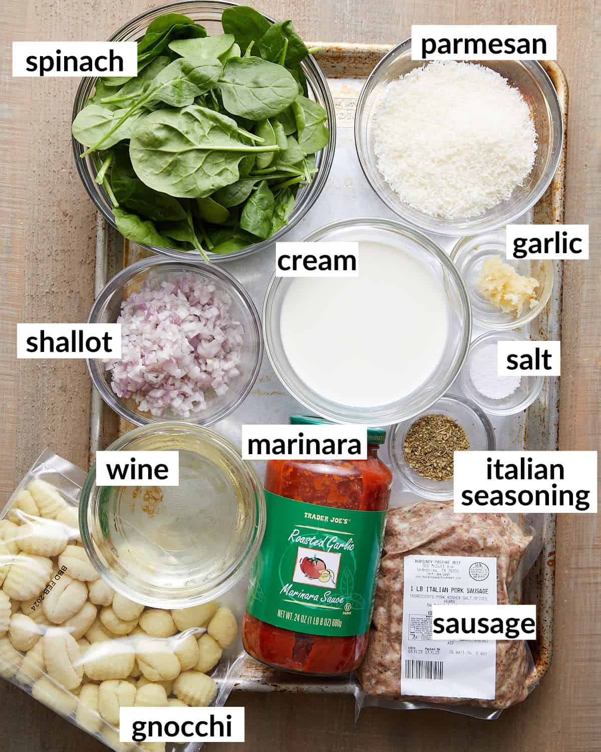 Overhead image of ingredients needed for sausage gnocchi with creamy tomato sauce and spinach. 
