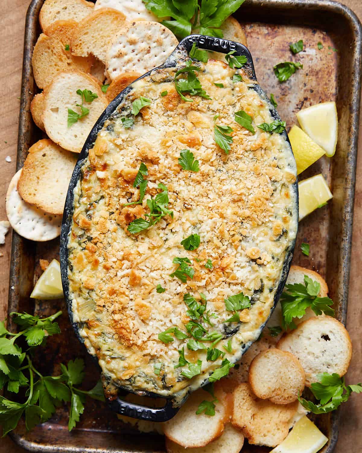 Overhead image of crab spinach artichoke dip with garnish.