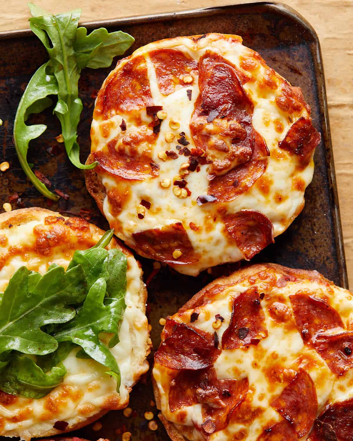 Up close image of air fryer english muffin pizzas.