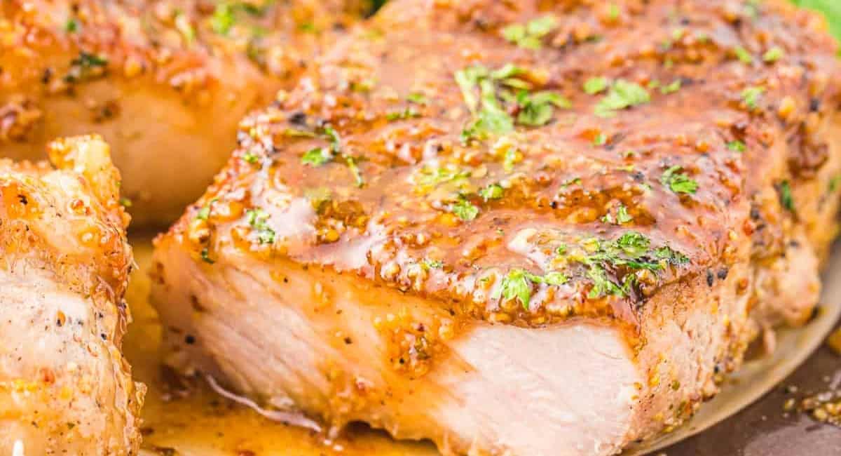 Up close image of honey mustard pork chop with garnish.