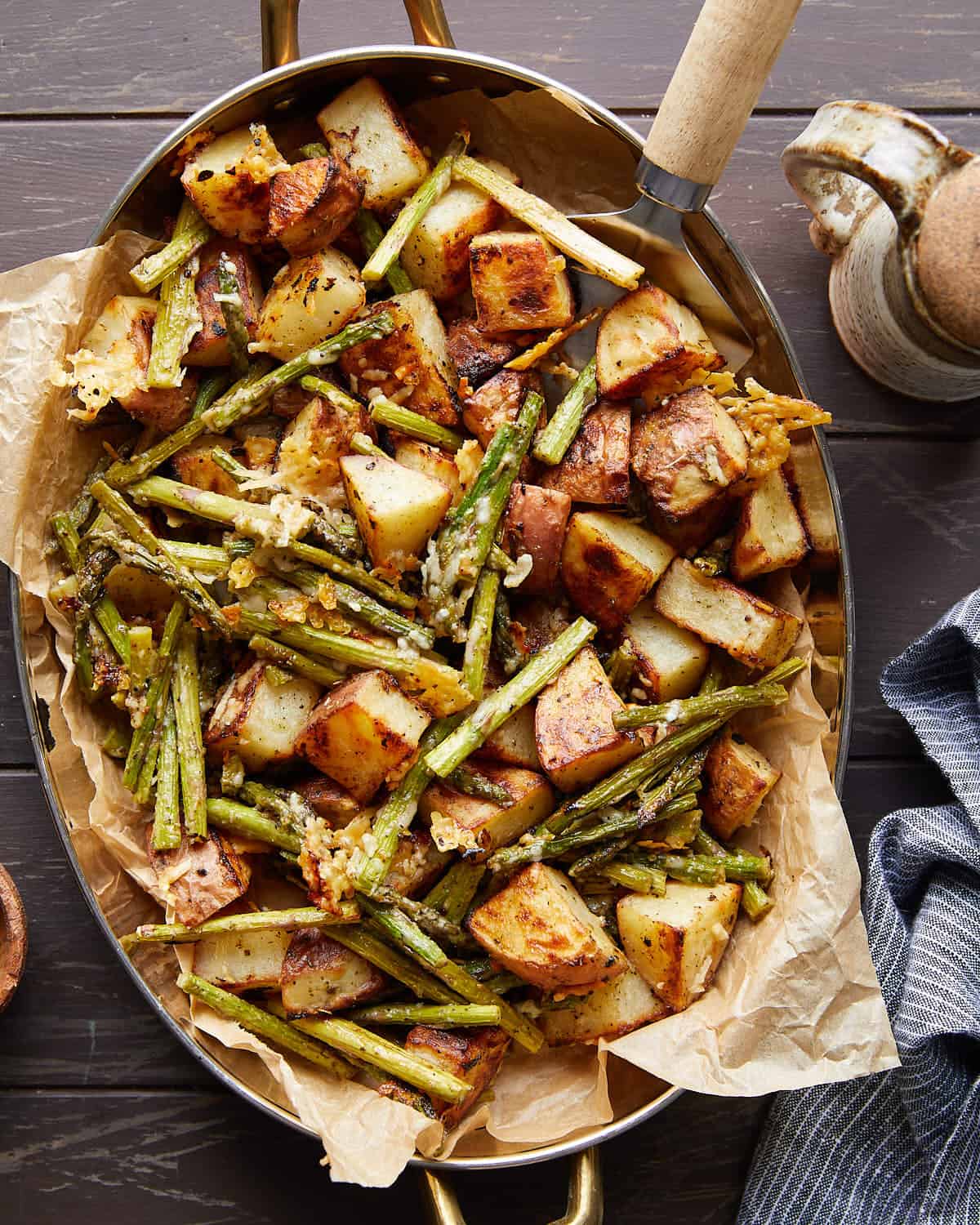 Overhead image of roasted potatoes and asparagus with garnish.
