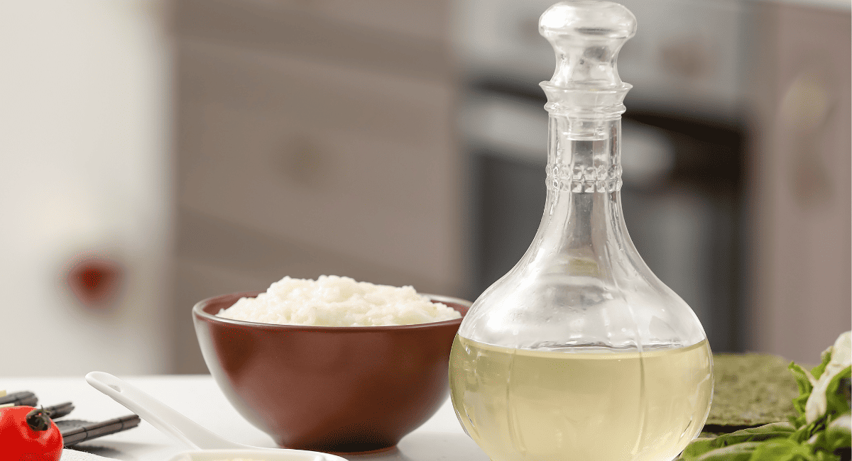 Image of rice vinegar next to bowl of rice.