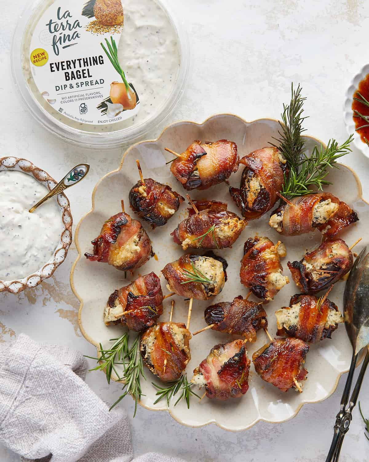 Overhead image of bacon wrapped dates with cream cheese and garnish. 