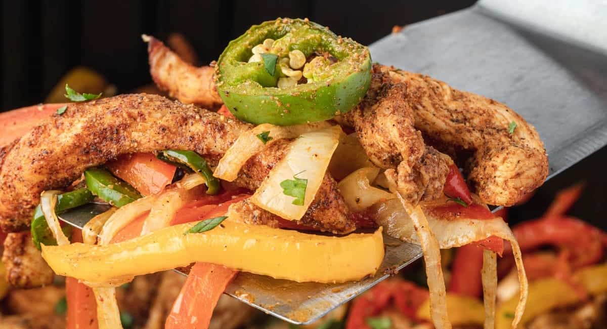 Up close image of air fryer chicken fajitas with garnish.