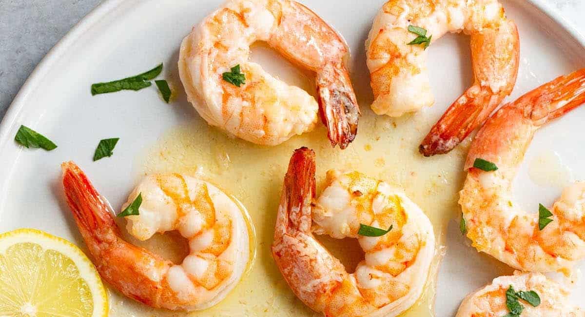 Overhead image of air fryer butter garlic shrimp with garnish.