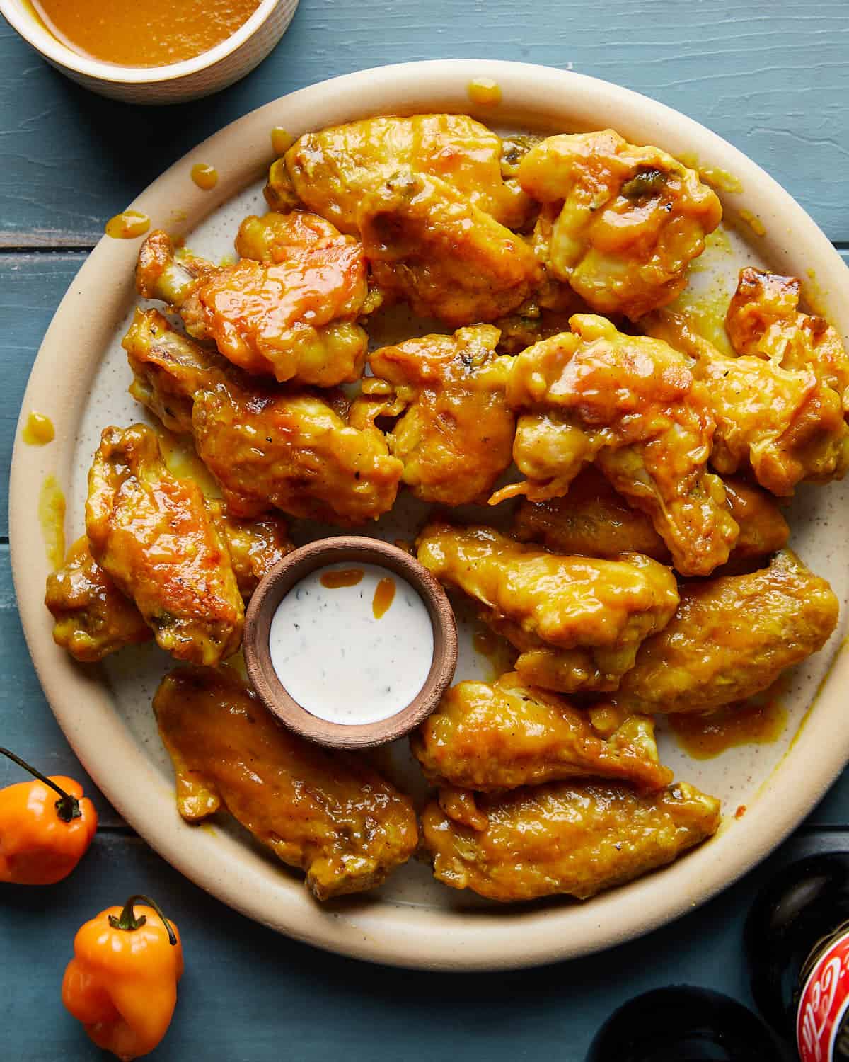 Overhead image of mango habanero wings with side of ranch dressing. 