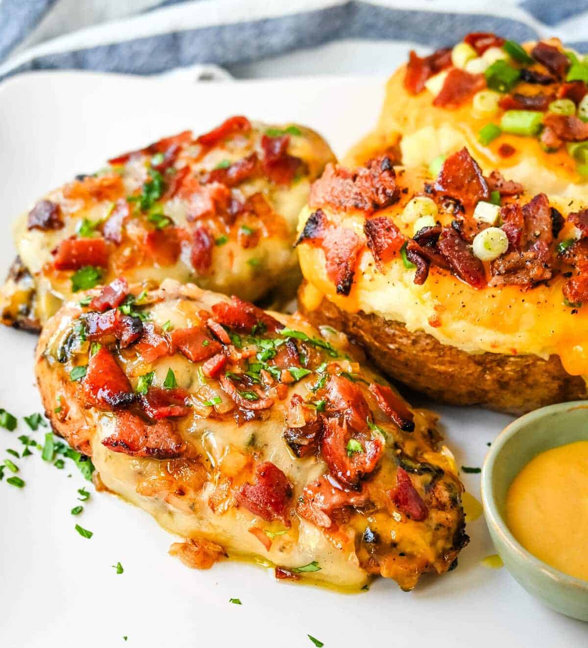 Up close image of cheesy bacon smothered chicken with garnish. 