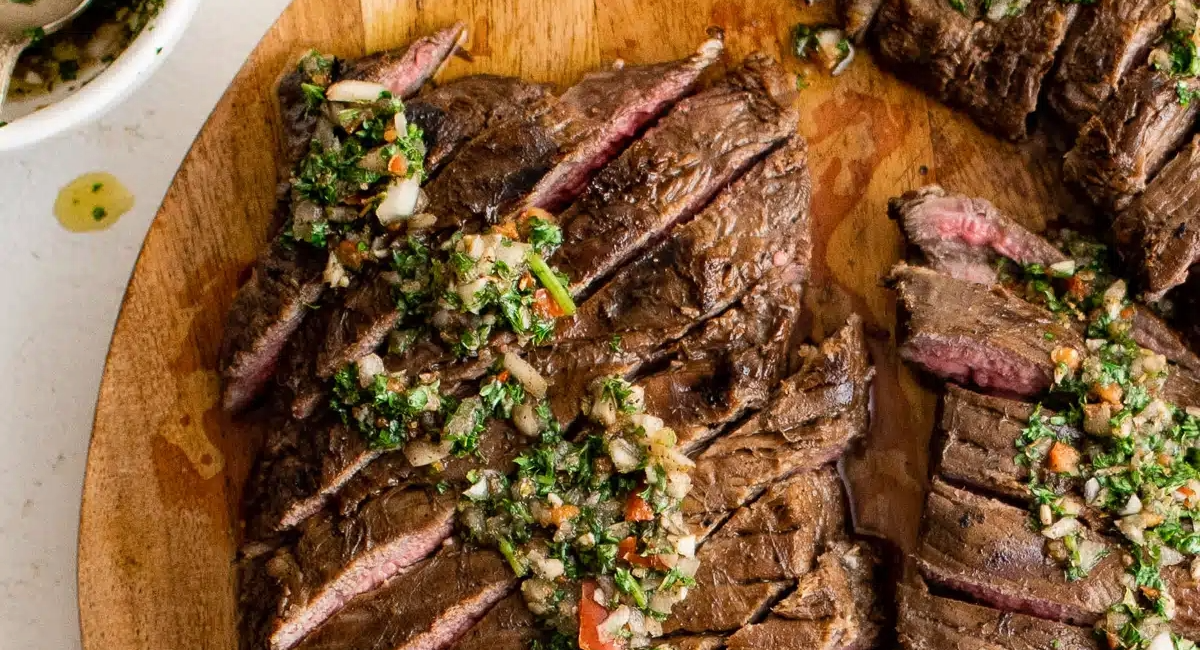 Overhead image of flank steak marinade with garnish. 